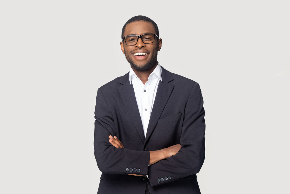 Smiling person in a suit with glasses