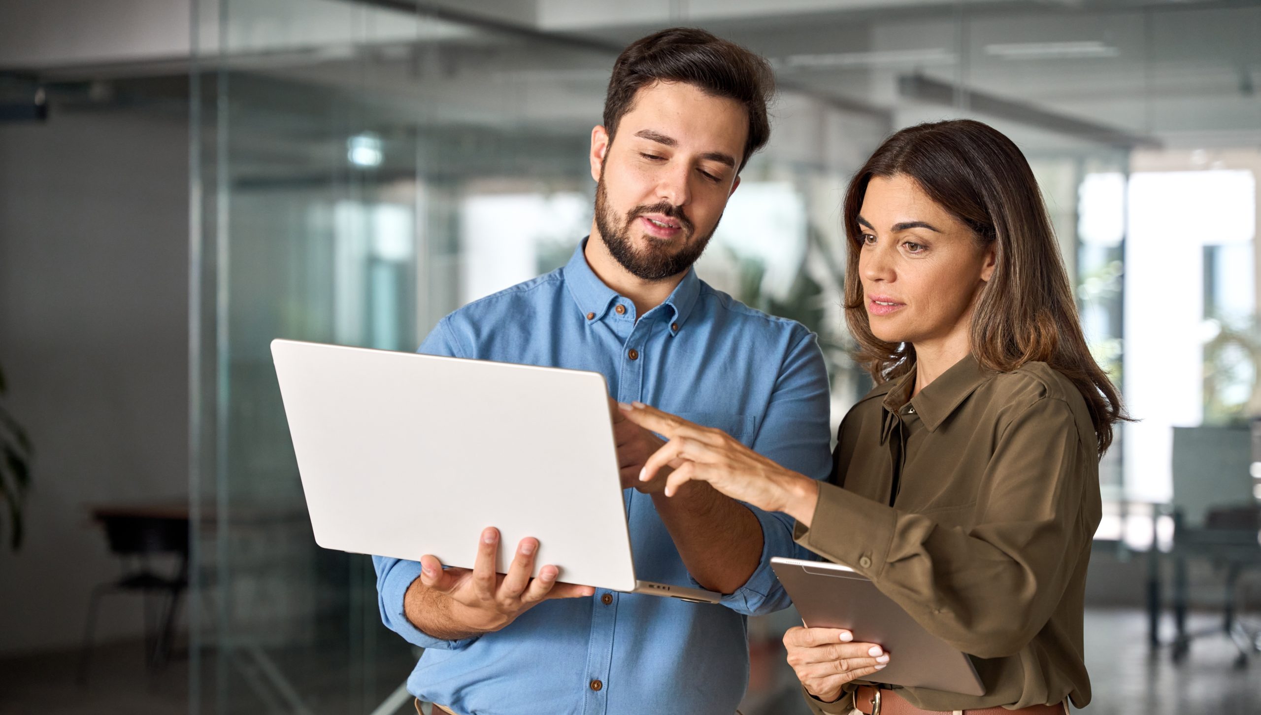 Two colleagues discussing work over a laptop.